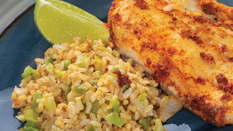 Cajun seasoned fish with rice and a slice of lime.